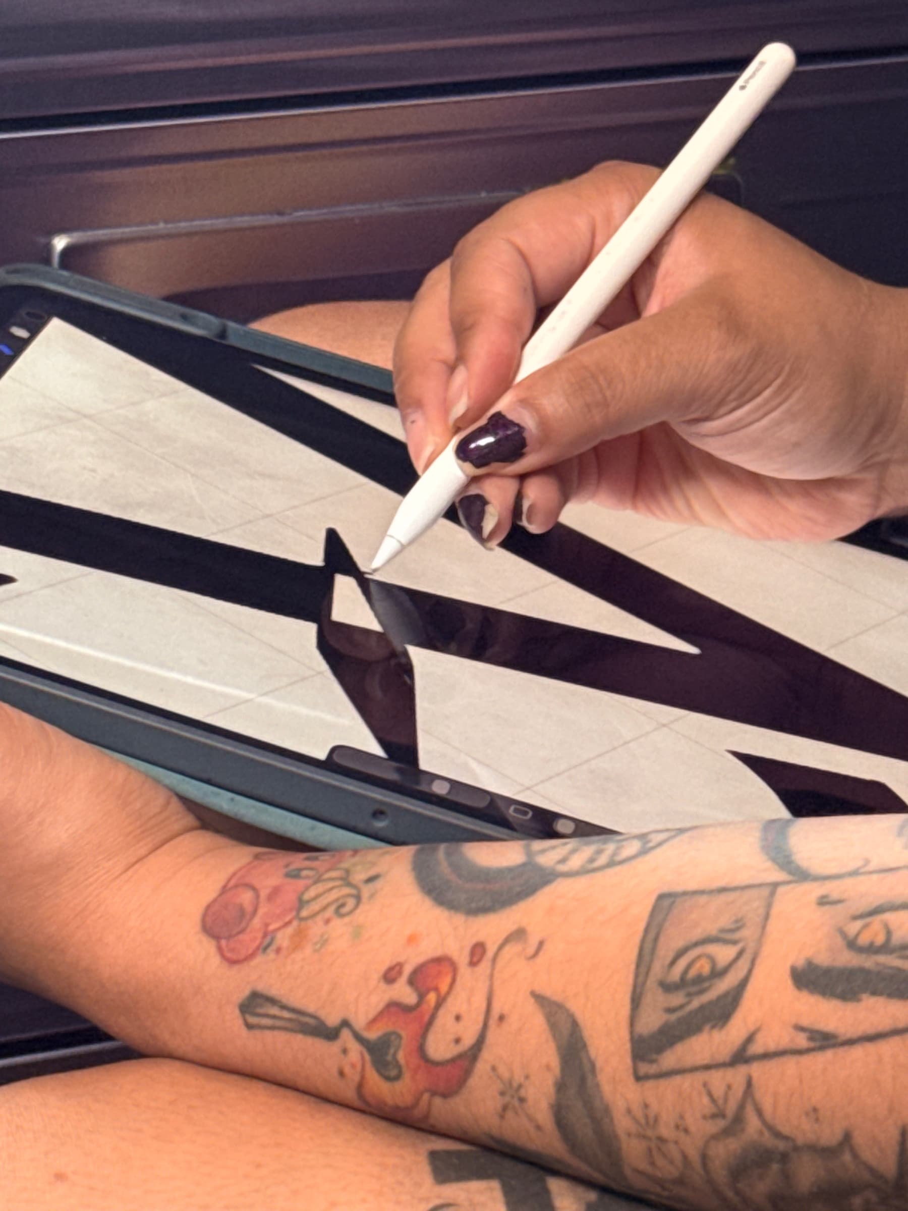 Tattoo artist Hailley Odie developing the mark on a tablet before tattooing.